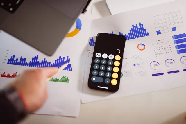 Business analytics setup with calculator, graphs, and laptop, showcasing financial insights. Vad styr priset på svenska tjänster?